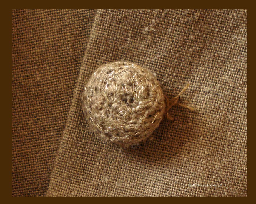 Crocheted button made from fabric ravelings and gold thread